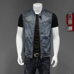 Detail of blue denim vest with stand collar, diamond quilting, and metal zipper pockets