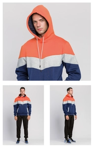 Detail of a men's color-block drawstring hoodie featuring orange, grey, and navy blue panels