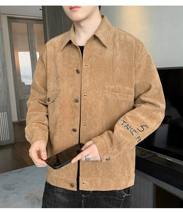 Detailed close-up of khaki corduroy jacket sleeve with blue and black 5 TAKE FN embroidery