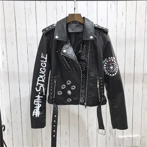 Détail de la veste punk en similicuir avec texte graffiti blanc et rivets métalliques