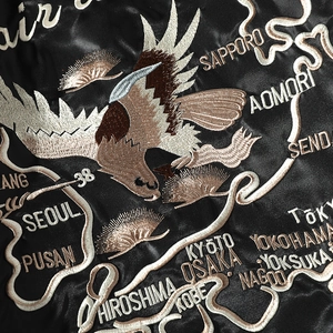 Detail showing high-quality eagle embroidery and Asian map on black satin flight jacket