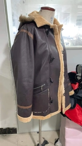 Detail der Kunstleder-Kapuzenjacke mit Plüschfutter und klassischem Knebelverschluss