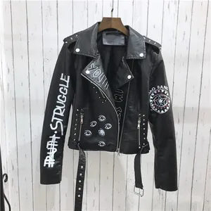 Détail d'un blouson motard en PU noir avec imprimé graffiti blanc et rivets métalliques