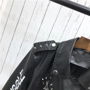 Détail de la veste de motard noire en PU avec rivets métalliques et graffiti sur la manche