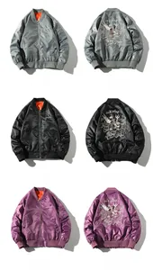 Close-up of three color bomber jackets showing detailed embroidery and orange lining
