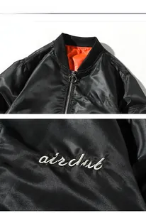 Detail view of the black MA-1 flight jacket featuring white airclub embroidery and orange lining
