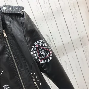 Détail de la veste de motard en similicuir avec clous métalliques et imprimé blanc