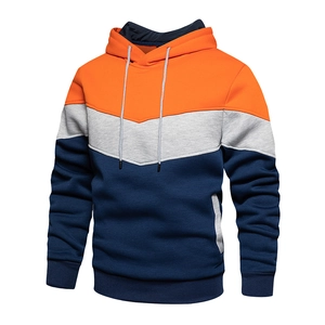 Detail view of tri-color patchwork hoodie with drawstrings, ribbed cuffs and side pockets