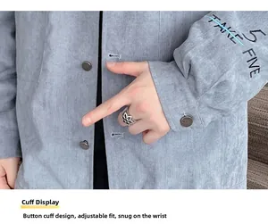Detail of light gray corduroy jacket cuff with Take Five embroidery and button closure