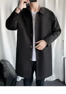 Detail of a men's black mid-length trench coat featuring a classic lapel and brown buttons