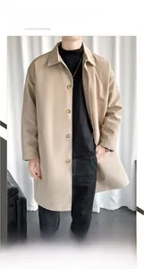 Detail of khaki men's mid-length trench coat with classic lapel and button cuff features