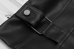 Detail of black faux leather texture with adjustable metal buckle and neat stitching