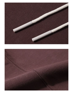 Détail macro du tissu bordeaux du sweat à capuche avec cordon tissé et couture fine