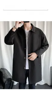 Detail of a minimalist black long-length windbreaker jacket with a classic lapel collar