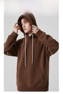 Détail d'un sweat à capuche marron lourd avec cordons blancs et poche kangourou sur un mannequin