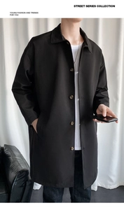 Close-up of black mid-length trench coat featuring a classic lapel and button closure