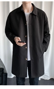 Detail of classic lapel and single-breasted buttons on men's black mid-length trench coat