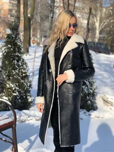 Détail d'un manteau d'hiver en similicuir noir avec doublure en peau de mouton blanche