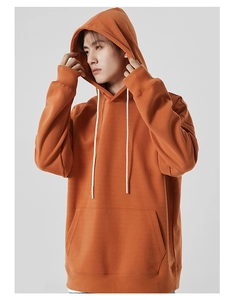 Détail d'un sweat à capuche orange avec cordons blancs et poche kangourou pratique
