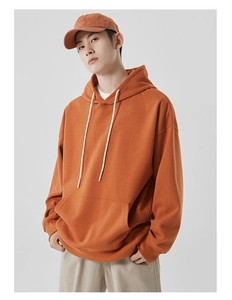 Vue détaillée d'un sweat à capuche orange en coton épais avec cordon et poche kangourou