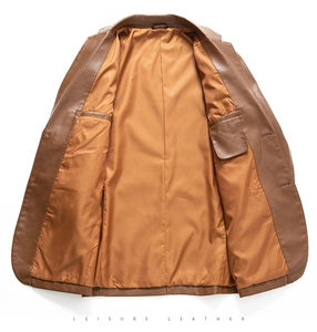 Dettaglio del blazer in pelle marrone che mostra la fodera dorata lucida e le tasche interne