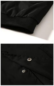 Close-up of black MA1 bomber jacket showing ribbed cuffs and metal snap button details