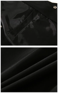 Detailed view of black MA1 bomber jacket fabric showing premium stitching and silver buttons