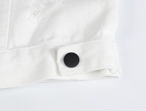 Gros plan d'un gilet en jean blanc avec détails usés et un bouton noir mat élégant