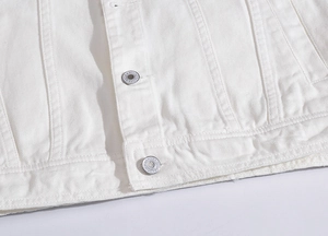 Detailed view of white denim vest hem with silver metal buttons and premium stitching