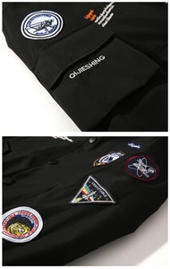 Detail of embroidered aviation patches and aerospace motifs on black bomber jacket
