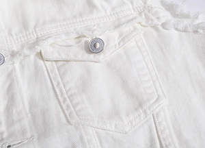 Detailed close-up of white denim vest featuring raw edges and metal branded buttons