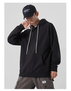 Détail d'un sweat à capuche noir en coton épais avec poche kangourou et cordons de serrage