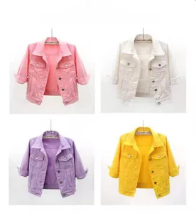 Detail view of colorful cropped denim jackets in pink, white, purple and yellow options