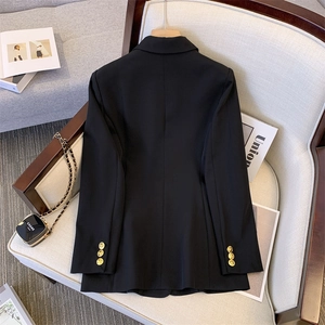 Women's black structured blazer with gold buttons and padded shoulders for casual chic style