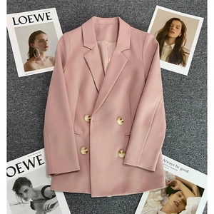Pink double-breasted women's blazer with peak lapels on textured background