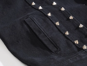 Macro shot of silver metal rivets on black denim vest with precise stitching details