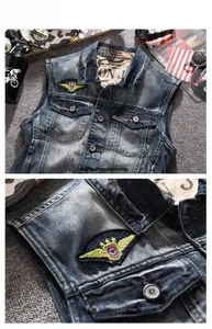 Detail of vintage washed denim vest featuring embroidered wing patches and utility pockets