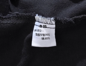 Detail view of the black fabric label showing 80% cotton and 20% polyester material blend