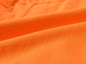 Macro shot of high-density orange cotton twill fabric showing detailed textile texture