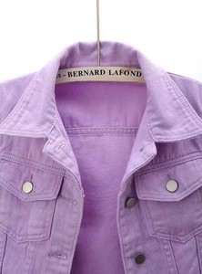 Detail of purple denim jacket collar and chest pockets with silver buttons