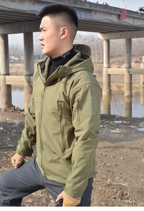 Detail of army green tactical softshell jacket with waterproof zippers and velcro cuffs