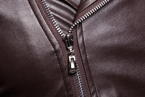 Close-up of silver metal zipper and dark brown litchi grain faux leather texture