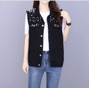Detail of black denim vest featuring white pearl embellishments and silver metal buttons