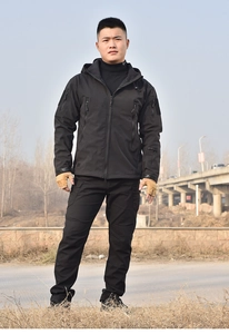 Detail of a black tactical softshell jacket and cargo pants for outdoor activities