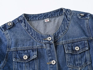 Détails de la veste en jean bleue avec col rond, boutons en métal et poches à rabat