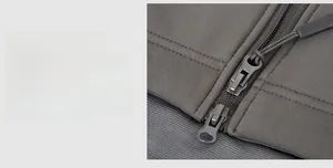 Detail of durable dual metal zipper system on charcoal tactical softshell jacket