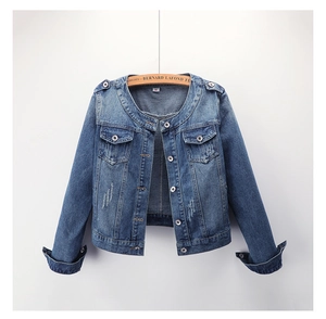 Détail d'une veste courte en jean bleu avec boutons métalliques et poches poitrine