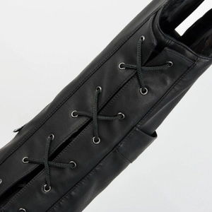 Detail of black leather vest featuring woven lace-up design and metal eyelets for biker style