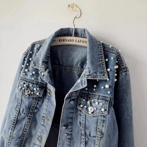 Light blue denim jacket with pearl embellishments on collar and pockets for women