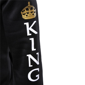 Detail of black hoodie sleeve featuring golden crown emblem and KING text print